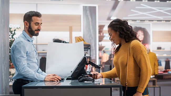 Woman paying for merchandise using mobile device