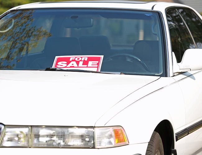 White car with for sale sign in the windshield White car with for sale sign in the windshield