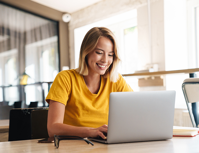 Smiling blonde woman working on laptop Smiling blonde woman working on laptop