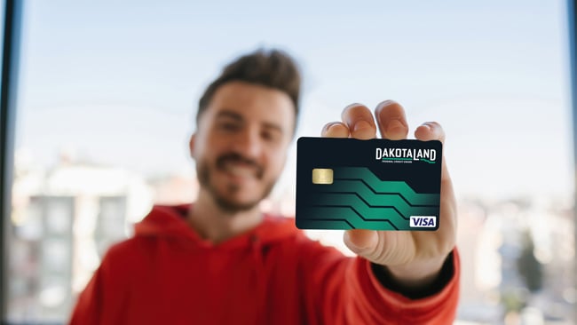 Guy holding Dakotaland Debit Card Guy holding Dakotaland Debit Card
