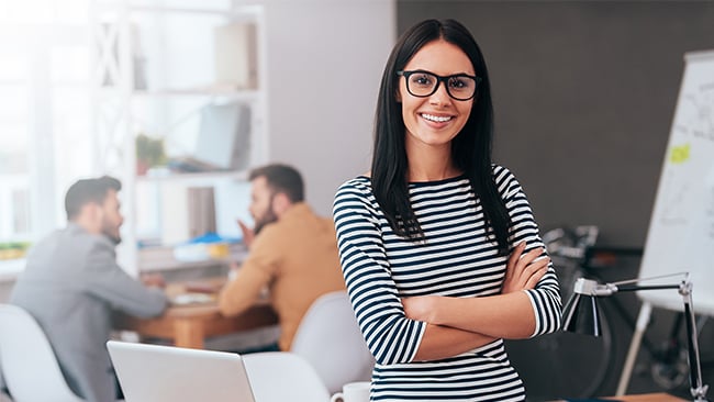 Business woman standing with arms crossed in office building