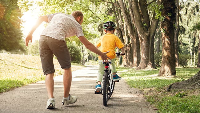 Man Helping Son Ride Bike Man Helping Son Ride Bike